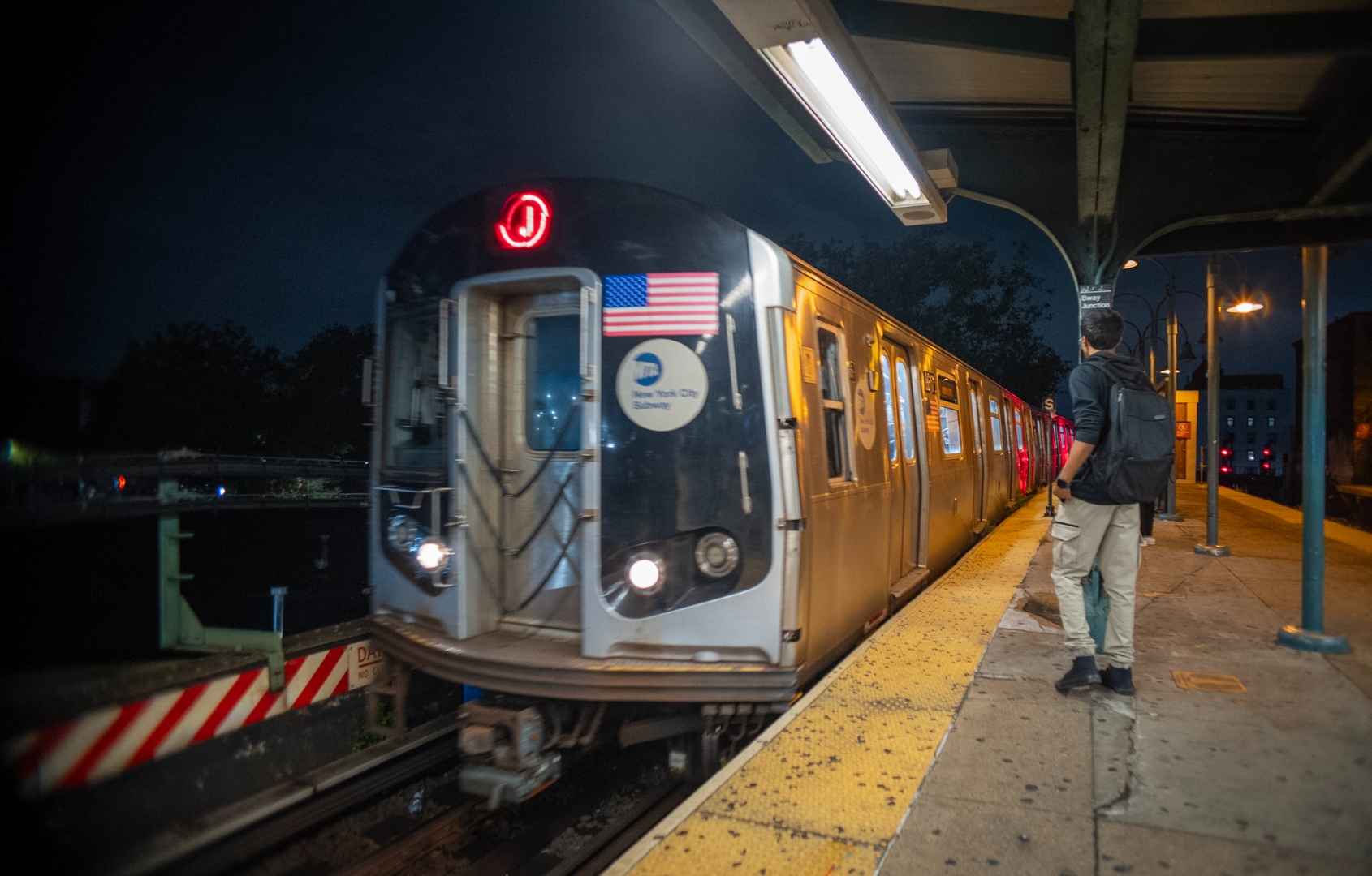 J train arriving at Broadway Junction station at night
